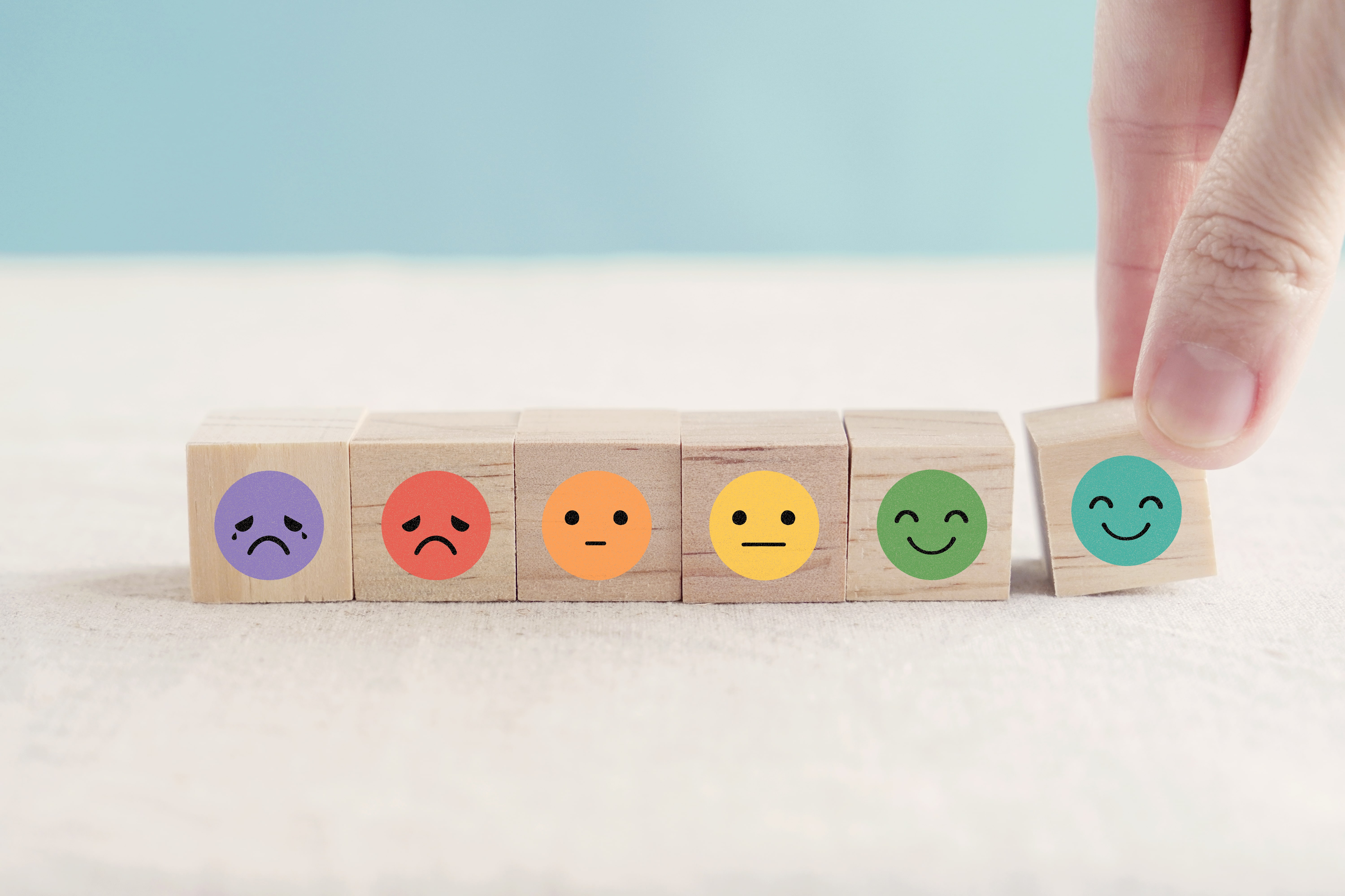 Woodenblocks with smileys ranging from sad to happy